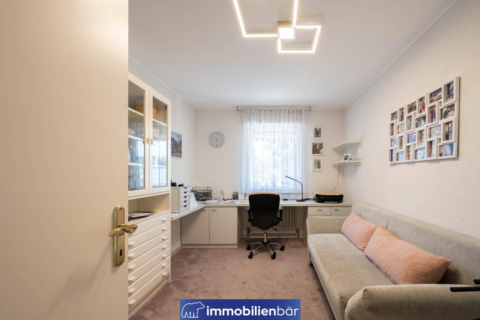 Helles Arbeitszimmer mit Schreibtisch, Sofa und Stauraum, ideal für Home-Office-Nutzung.