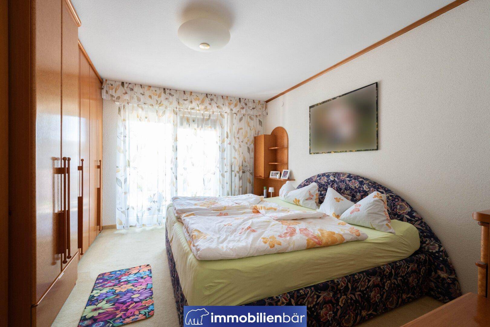 Schlafzimmer im traditionellen Stil mit Doppelbett, Teppichboden und Zugang zum Balkon.