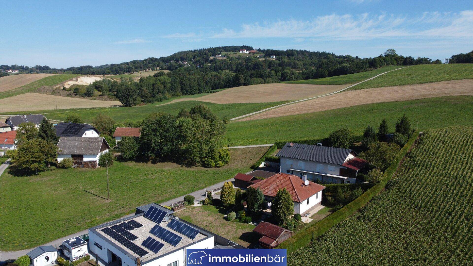 Luftaufnahme des Anwesens mit umliegender ländlicher Landschaft und Photovoltaikanlage auf dem Dach.