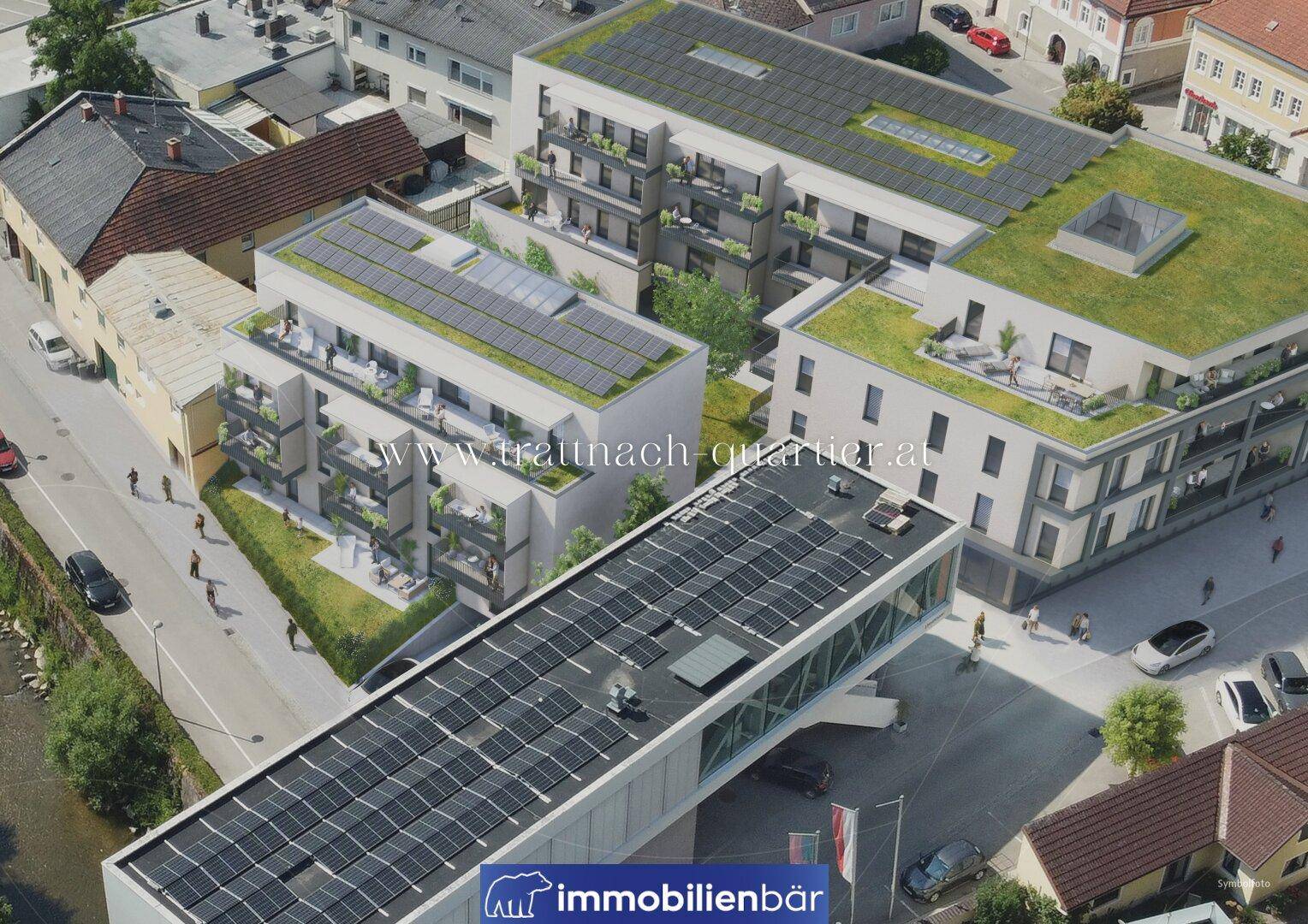 Luftaufnahme einer modernen Wohnanlage mit Solaranlagen auf den Dächern und begrünten Flachdächern.