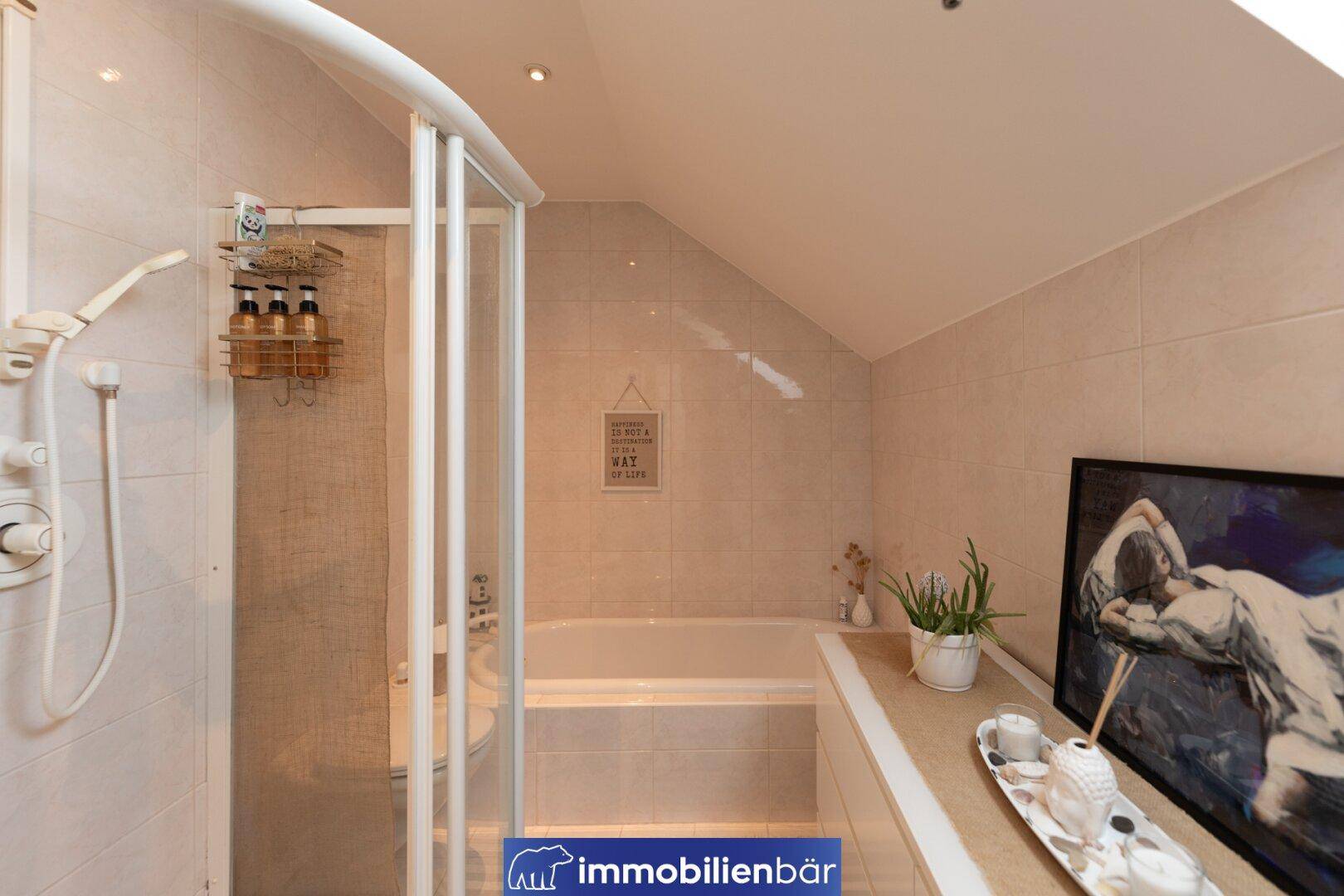 Funktionales Badezimmer mit Duschkabine und integrierter Badewanne, komplett gefliest.