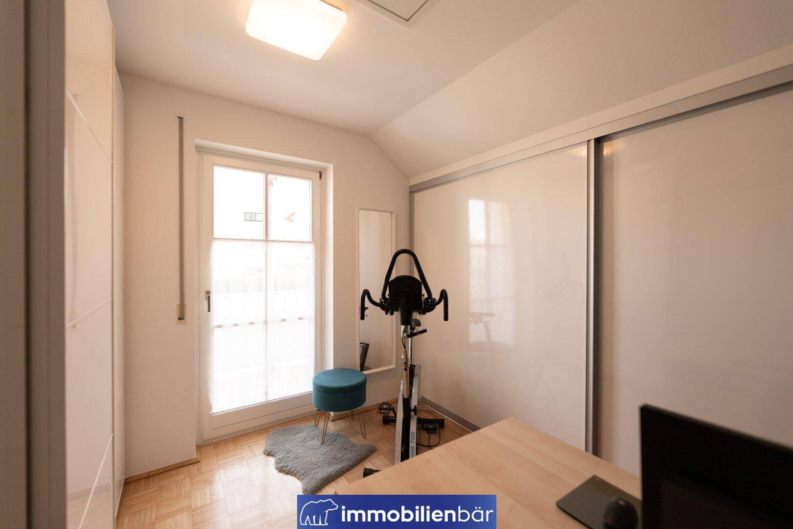 Helles Zimmer mit Schiebetürenschrank, Schreibtisch und Zugang zum Balkon oder Garten.