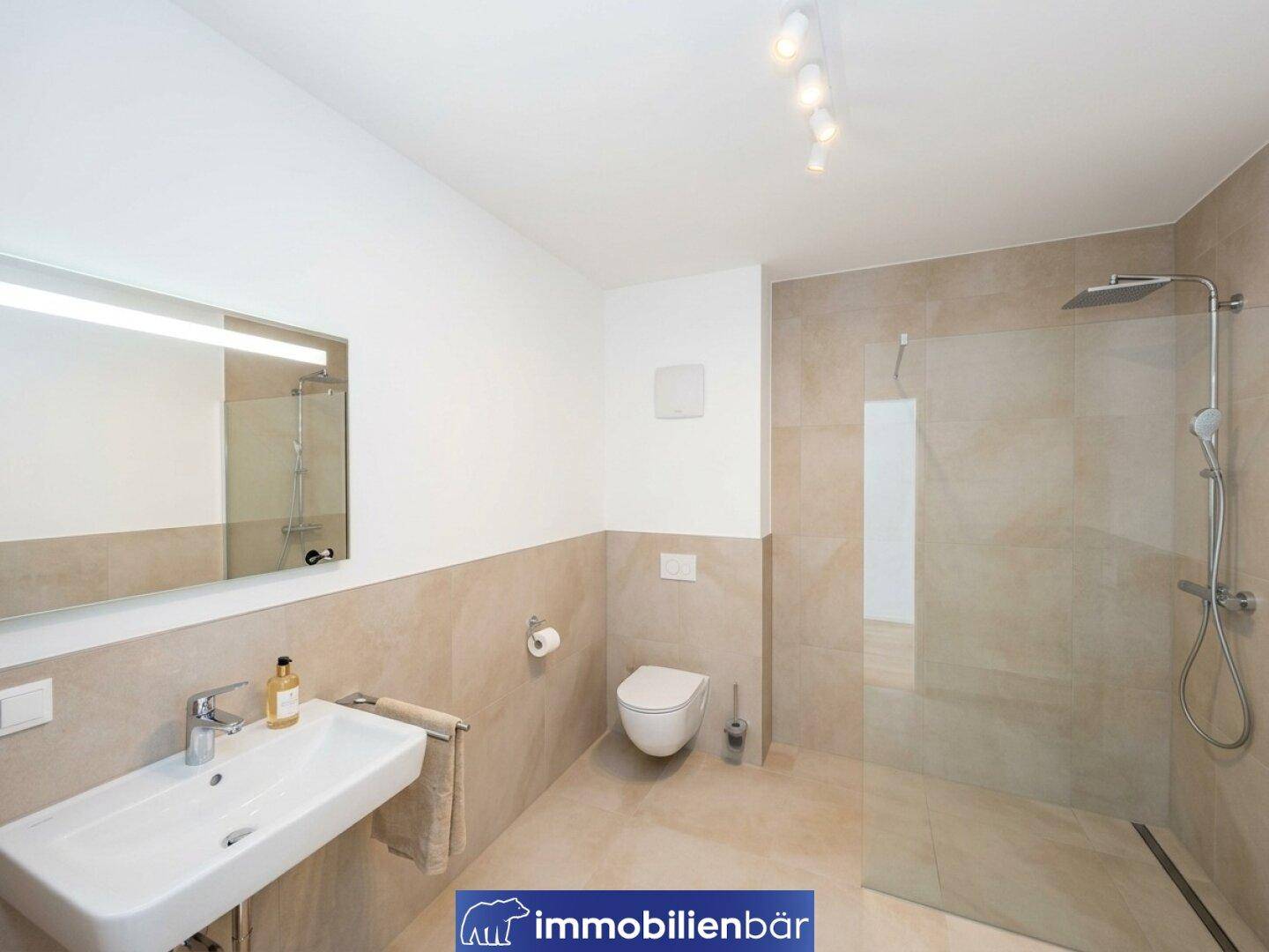 Modernes Badezimmer mit ebenerdiger Dusche, Wand-WC und großem Spiegel.