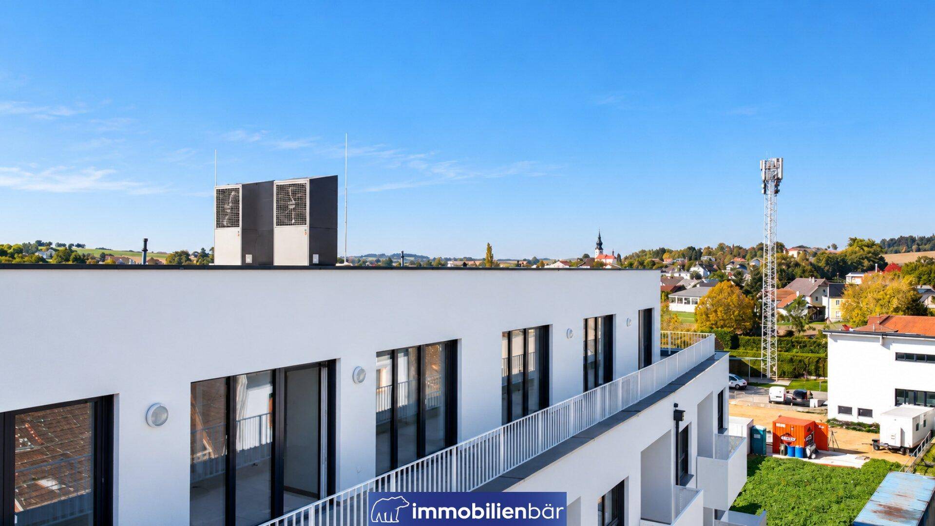 Dachansicht des modernen Gebäudes mit Lüftungsanlagen und Blick auf die Umgebung.