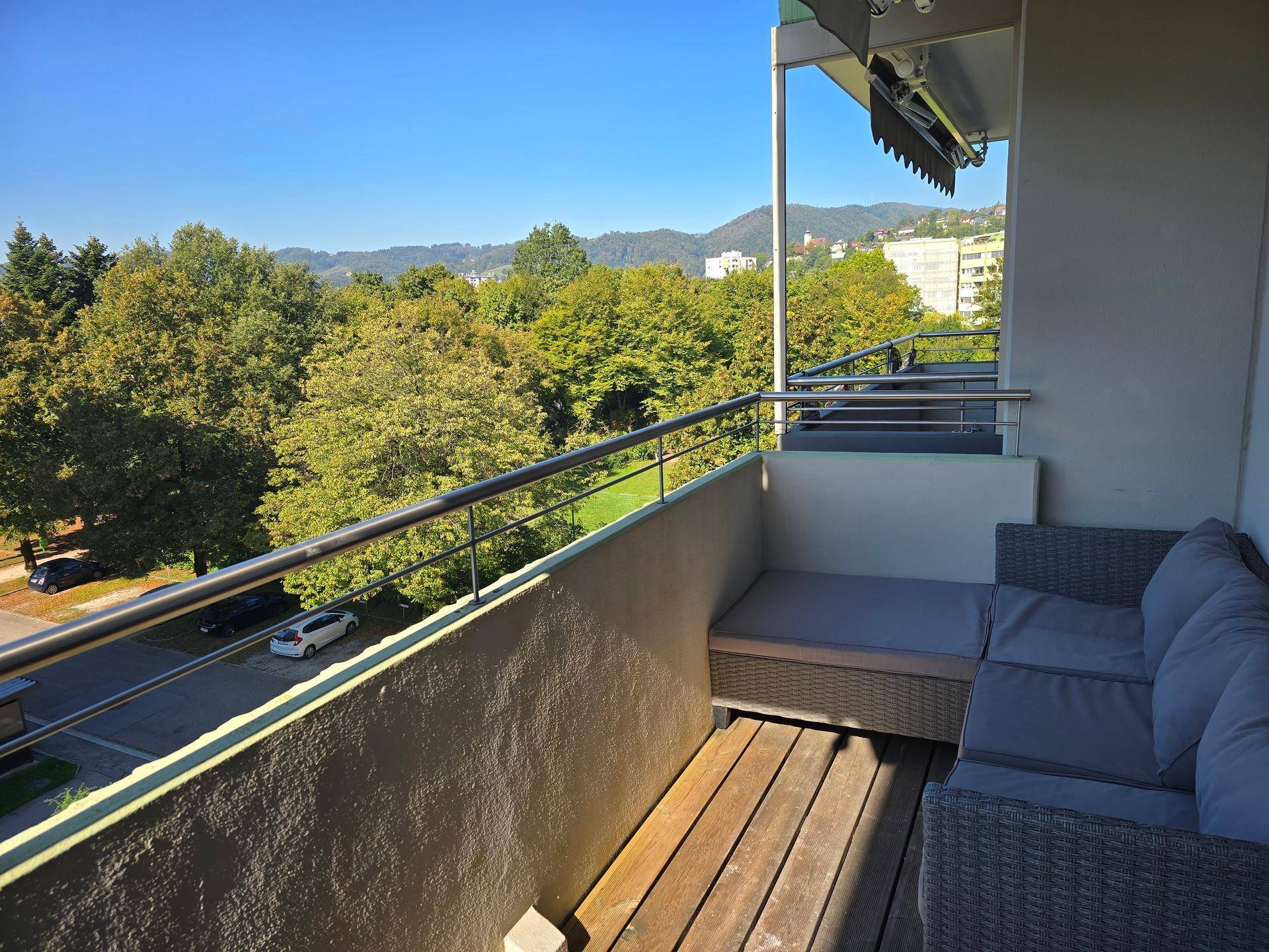 Geräumiger Balkon mit bequemen Outdoor-Möbeln und weitem Blick ins Grüne.