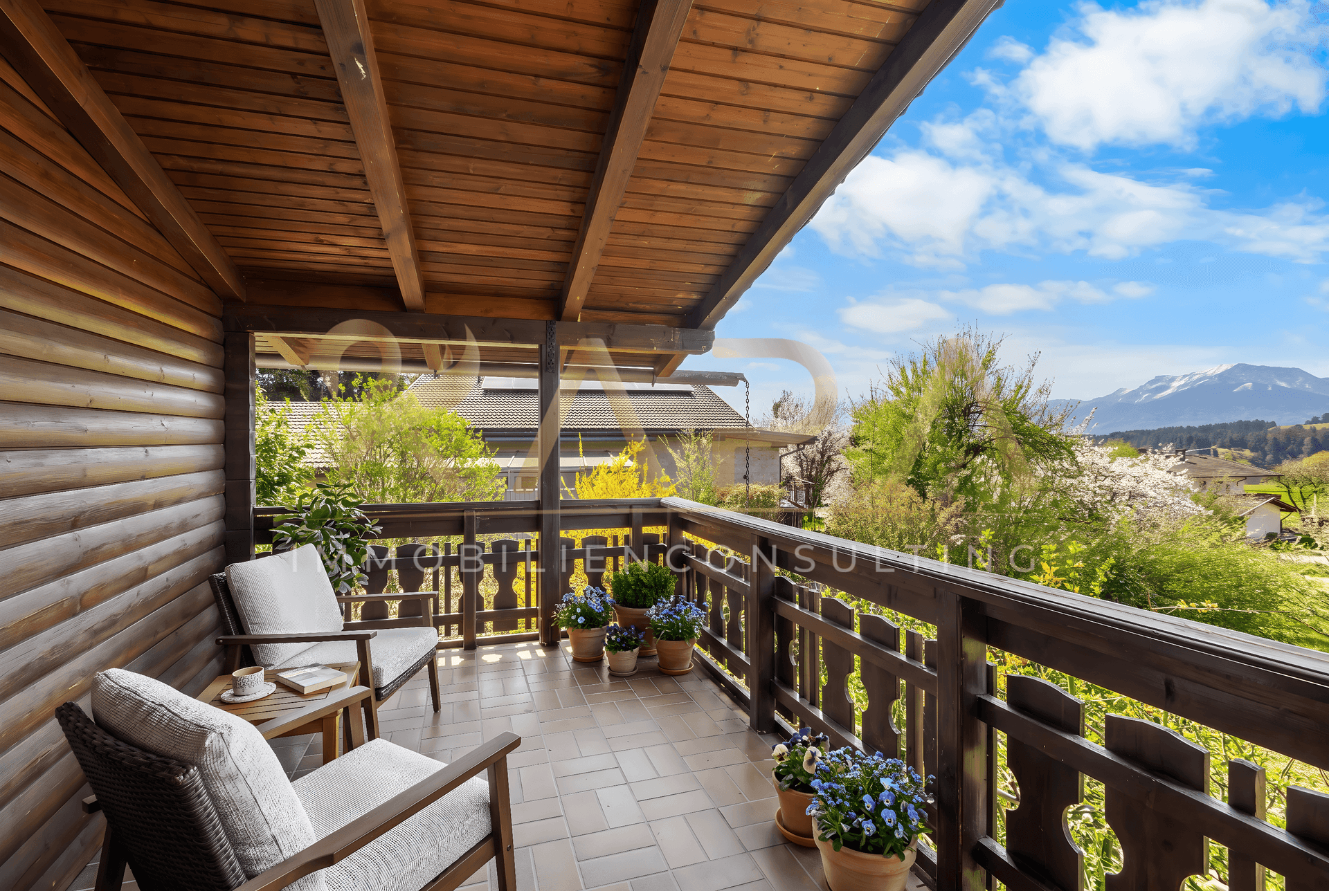 Überdachter Balkon mit Holzelementen, gemütlichen Sitzgelegenheiten und weitem Bergblick.