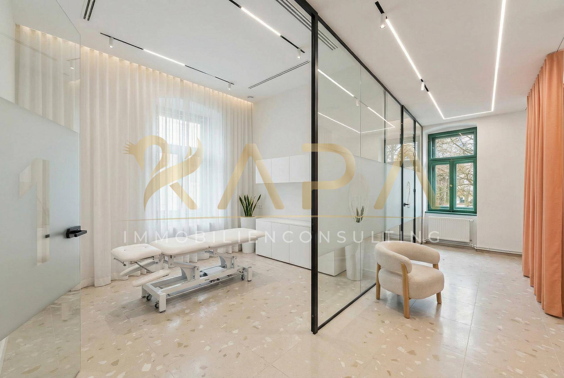 Heller Behandlungsraum mit Glaswänden, Liege und modernem Design, ideal für therapeutische Anwendungen.