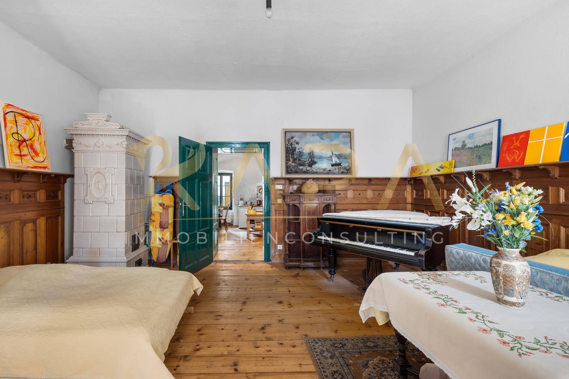 Gemütliches Zimmer mit Holzdielenboden, Kachelofen und Klavier, mit traditioneller Holzvertäfelung.