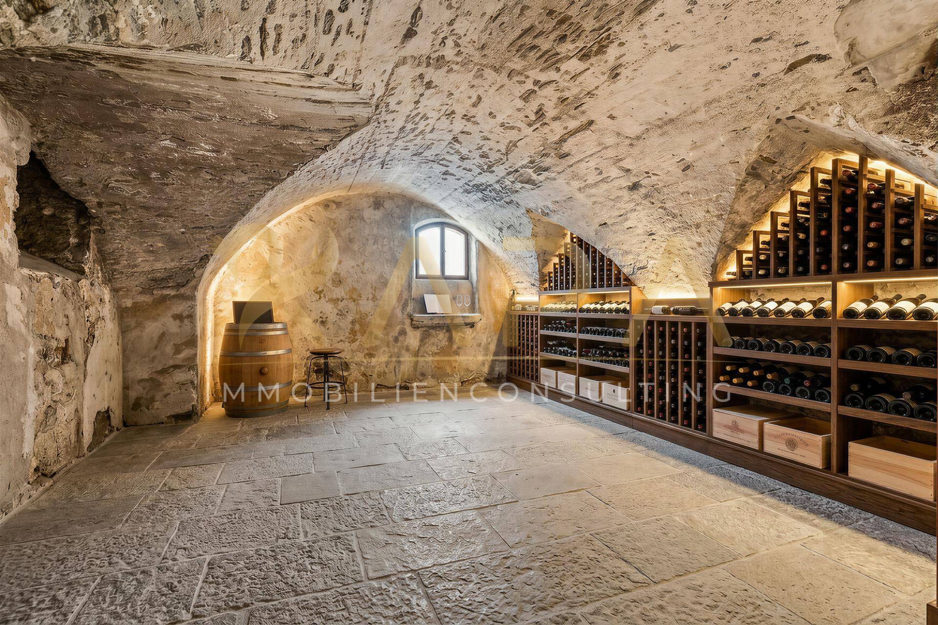 Historischer Weinkeller mit Gewölbedecke, Steinboden und umfangreichen Weinregalen für Lagerung und Verkostung.