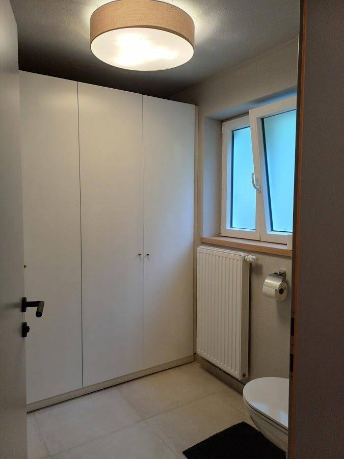 Kleines WC mit Fenster, Heizkörper und praktischen Einbauschränken.