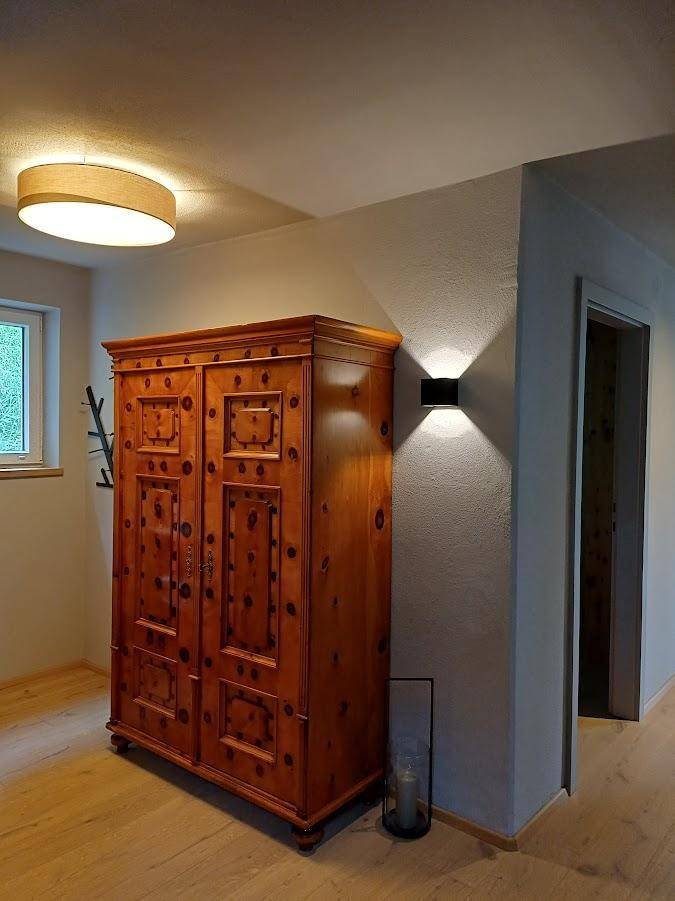 Gemütlicher Flurbereich mit einem traditionellen Holzschrank und indirekter Beleuchtung.