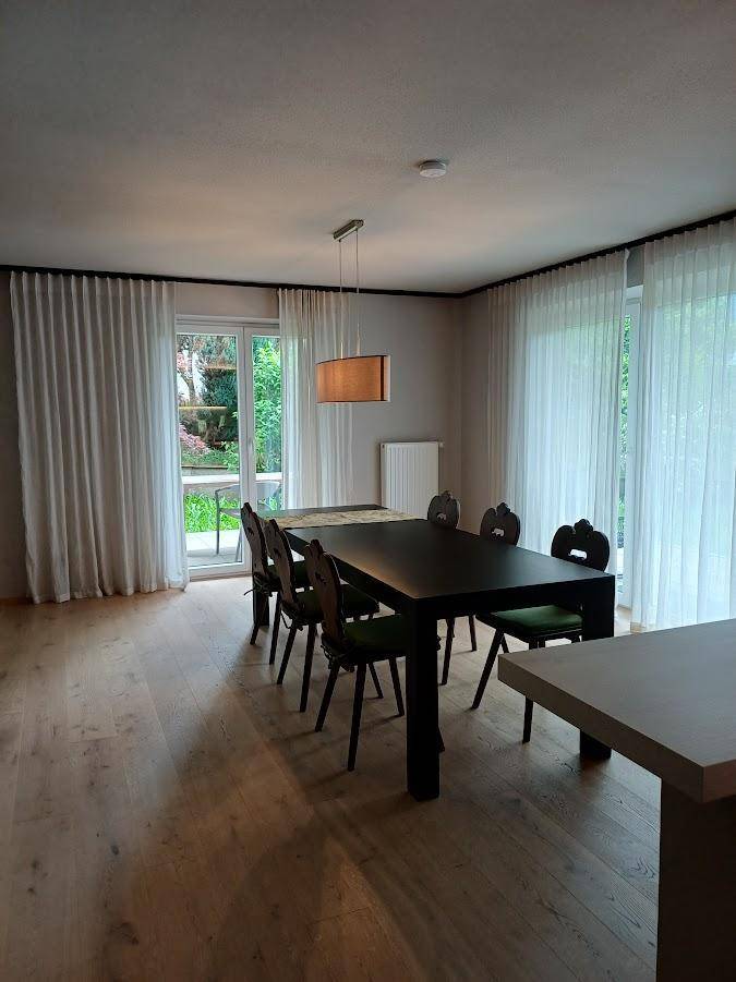 Heller Essbereich mit großem Esstisch und direktem Zugang zur Terrasse und zum Garten.