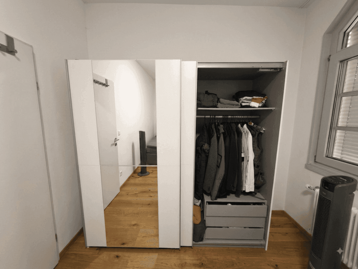 Großer Kleiderschrank mit Spiegeltüren und offener Sektion in einem hellen Raum mit Holzboden.