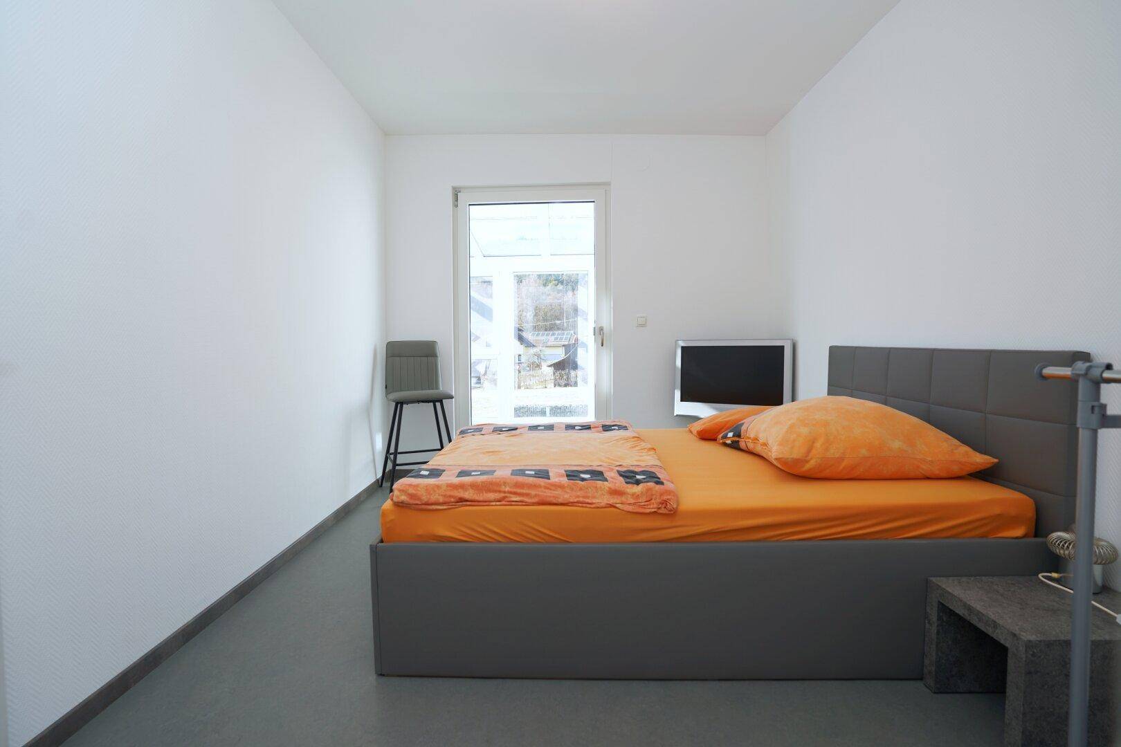 Helles Schlafzimmer mit Einzelbett und schlichtem, funktionalem Design.