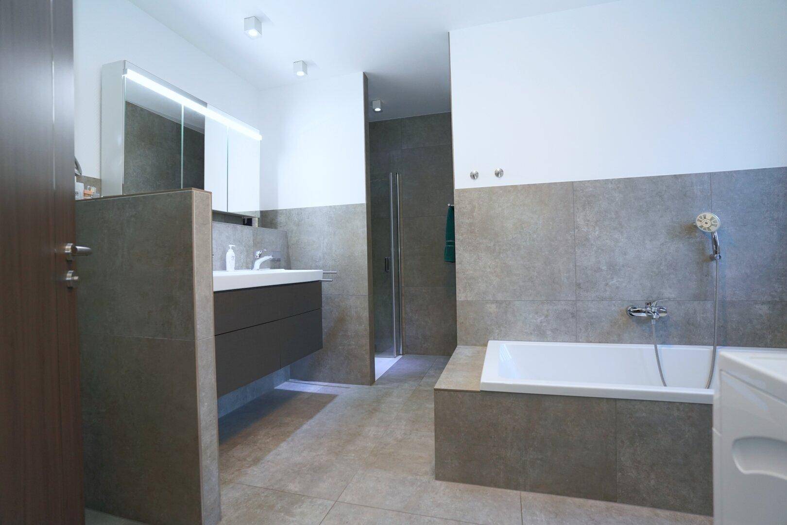 Modernes Badezimmer mit Badewanne, Dusche und Doppelwaschbecken.