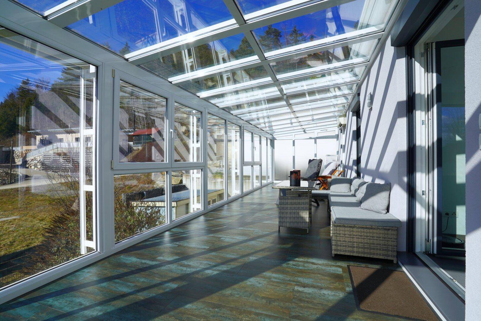 Geräumiger Wintergarten mit viel Glas, der einen hellen und offenen Wohnraum schafft.