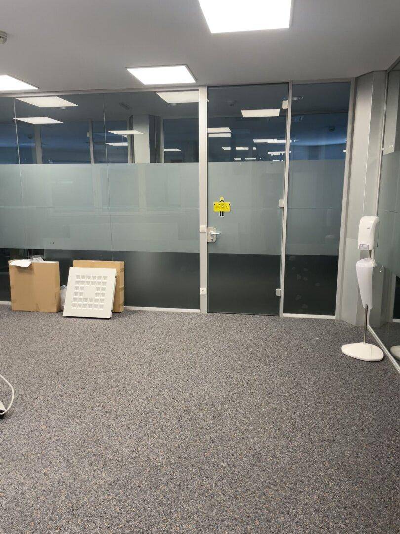 Büroraum mit modernen Glaswänden, die für eine offene und helle Arbeitsumgebung sorgen.
