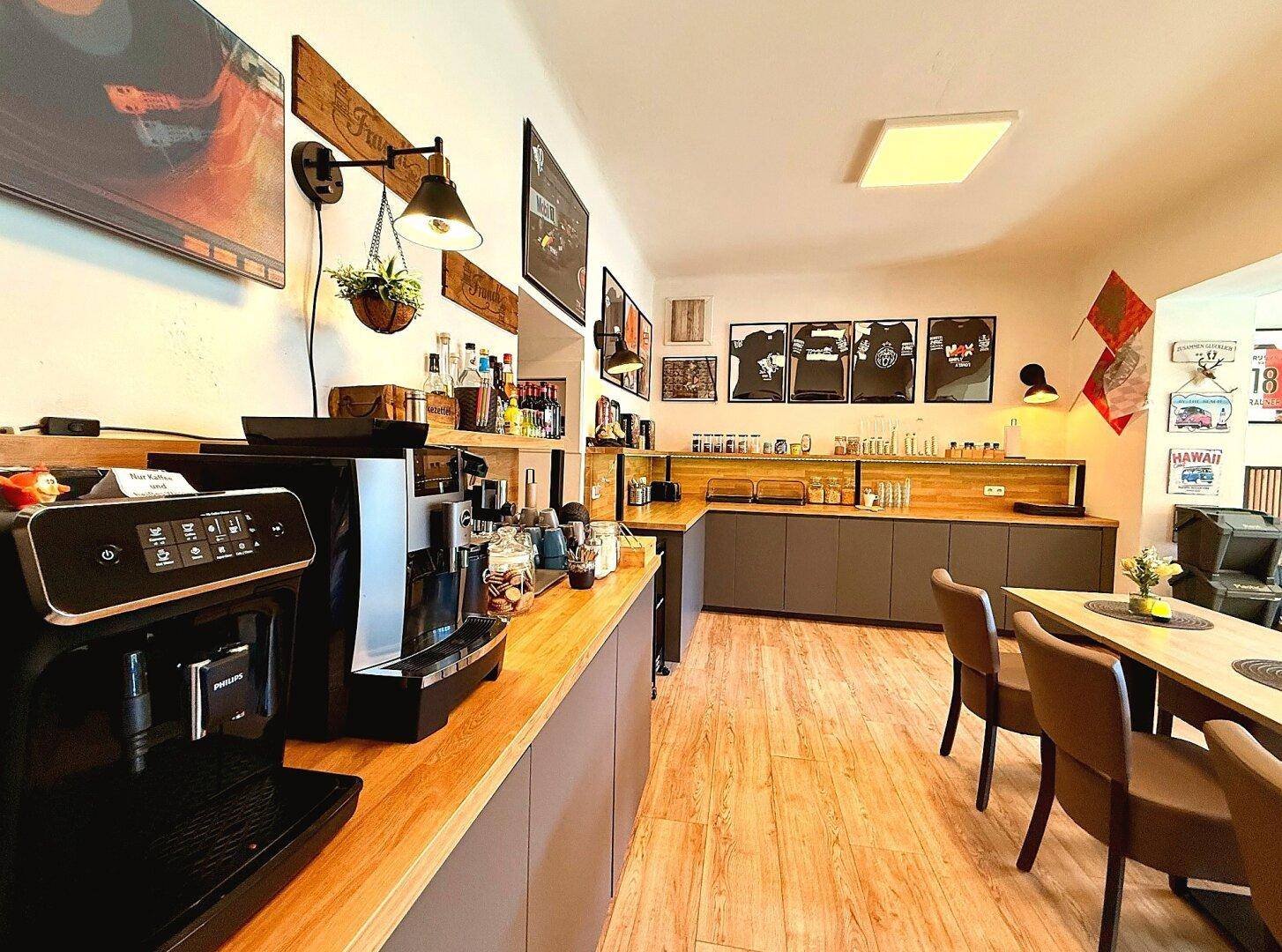 Moderne Küche mit Holztheken, grauen Schränken und Kaffeemaschine, ideal für Frühstück.