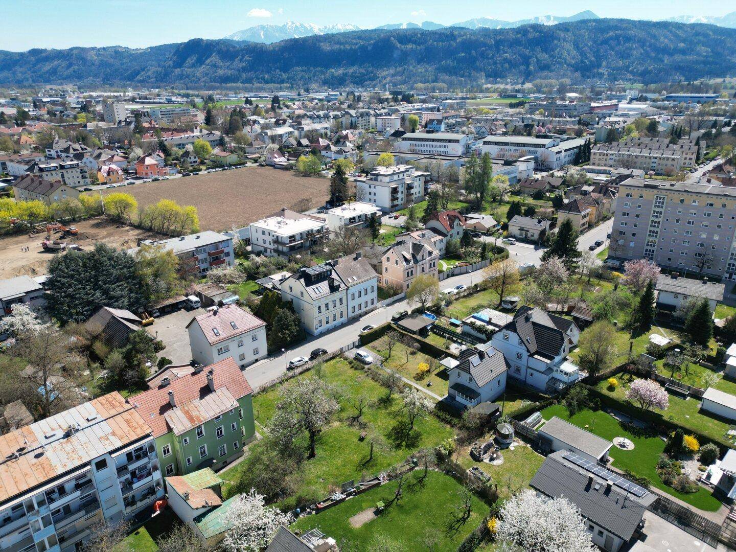 Panoramablick aus der Luft auf die Stadtlandschaft mit Bergen am Horizont.