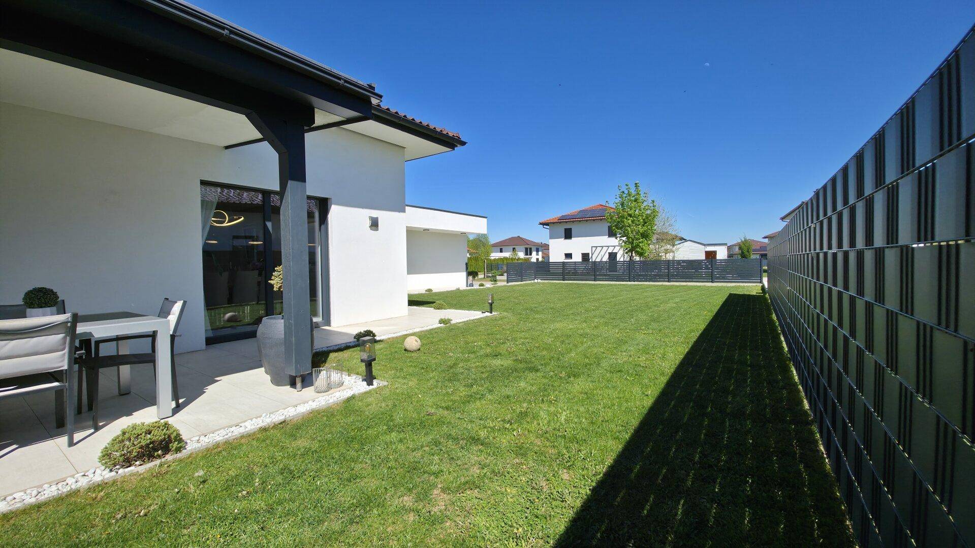 Gepflegter Gartenbereich mit kleiner Terrasse und Rasenfläche, ideal für entspannte Stunden im Freien.