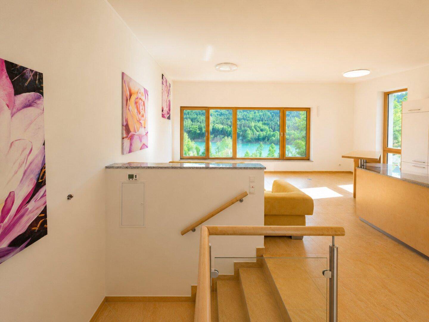 Eingangsbereich mit Treppe und offenem Übergang zum Wohnbereich mit Seeblick.