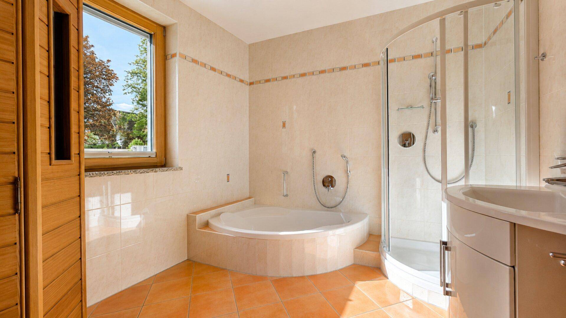Badezimmer mit Eckbadewanne, Duschkabine, Waschbecken und einem Fenster, inklusive Sauna.