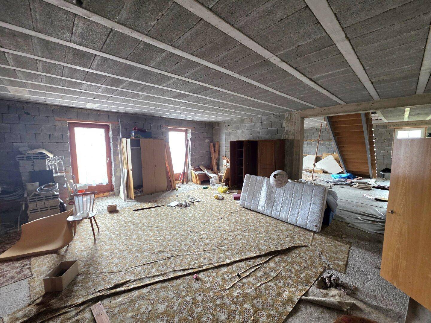 Unfertiger Innenraum mit Betonwänden und -decke, bereit für den Ausbau und die Gestaltung.