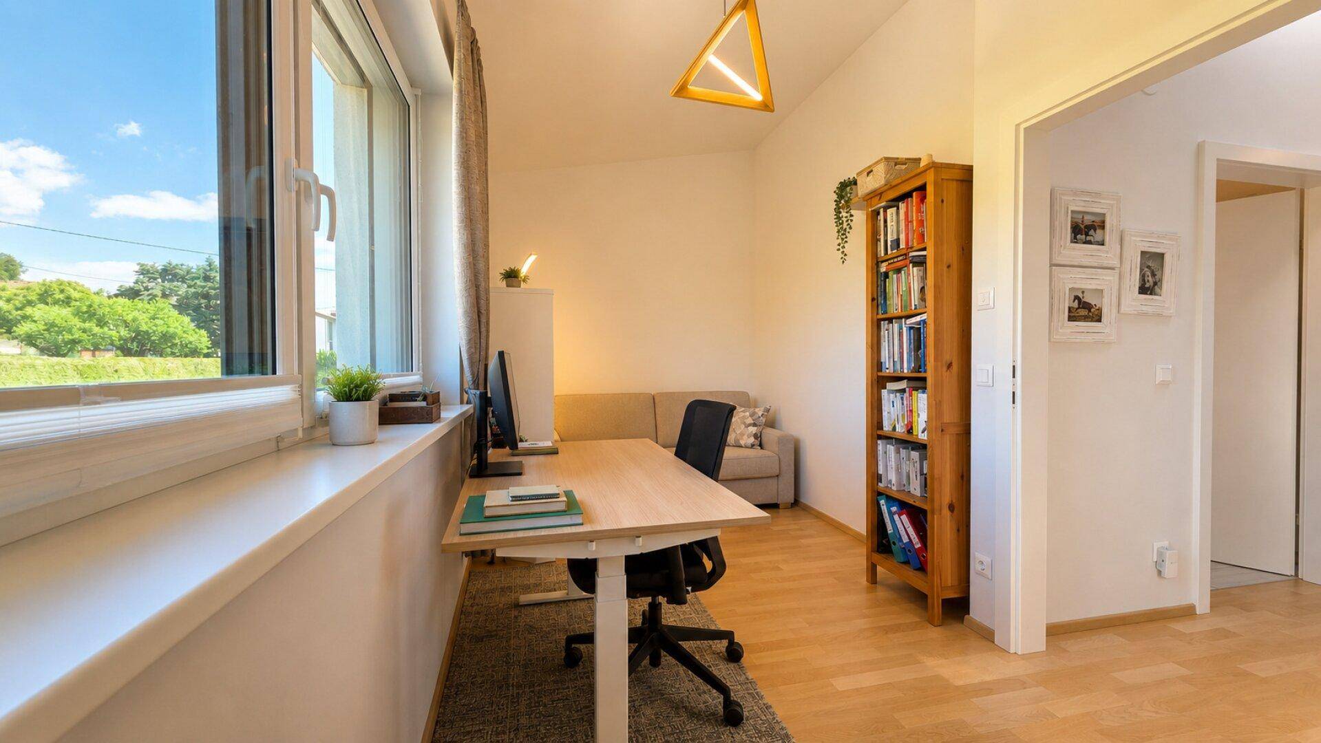 Funktionales Arbeitszimmer mit Schreibtisch, Bücherregal und viel Tageslicht.