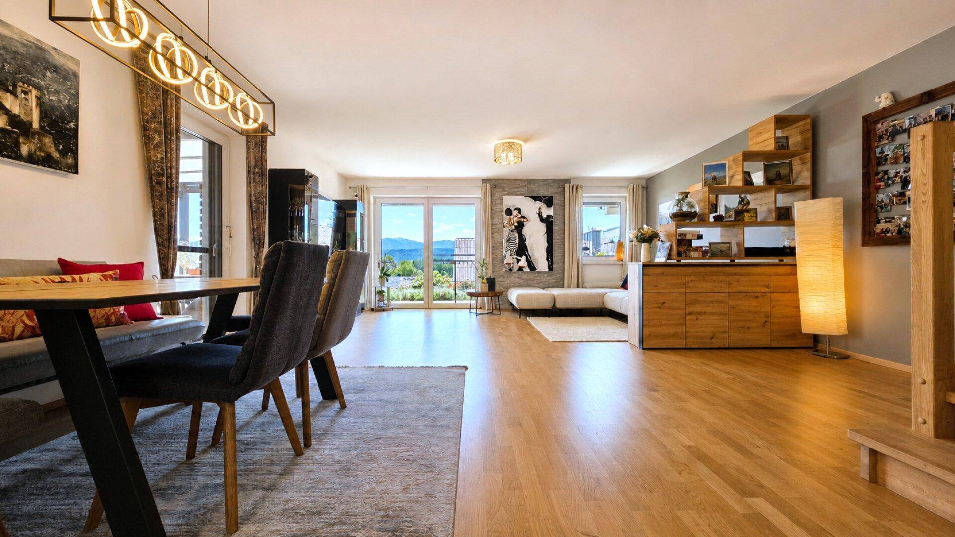 Geräumiger Wohn-Essbereich mit Holzboden, großem Esstisch und Zugang zur Terrasse.