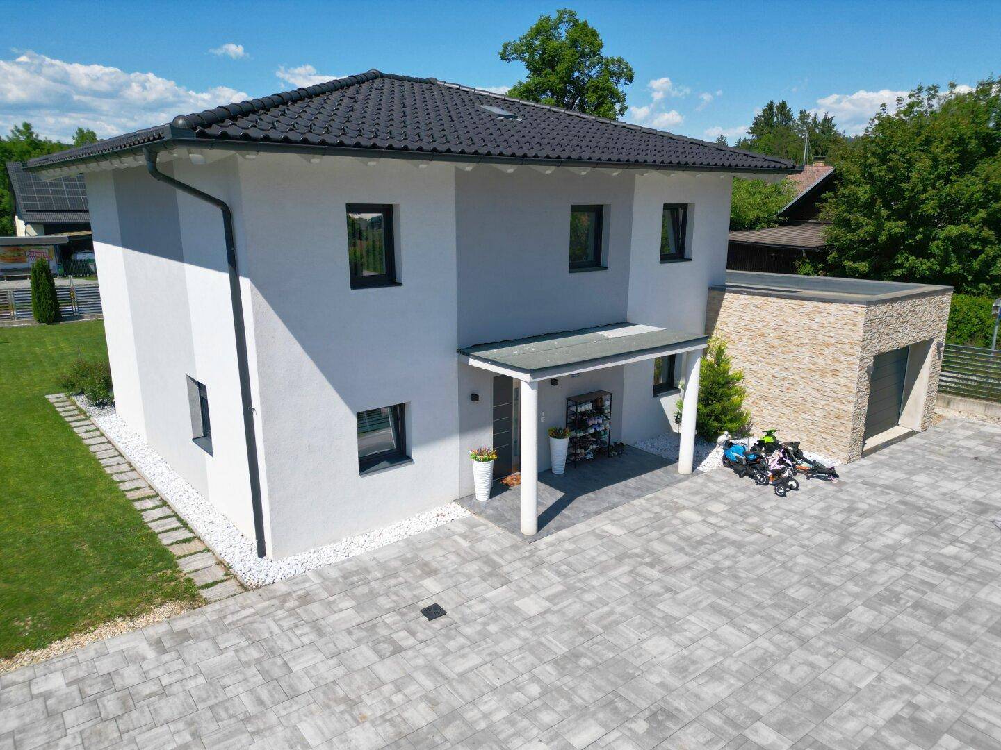 Seitenansicht des modernen Einfamilienhauses mit überdachtem Eingang und Garage.