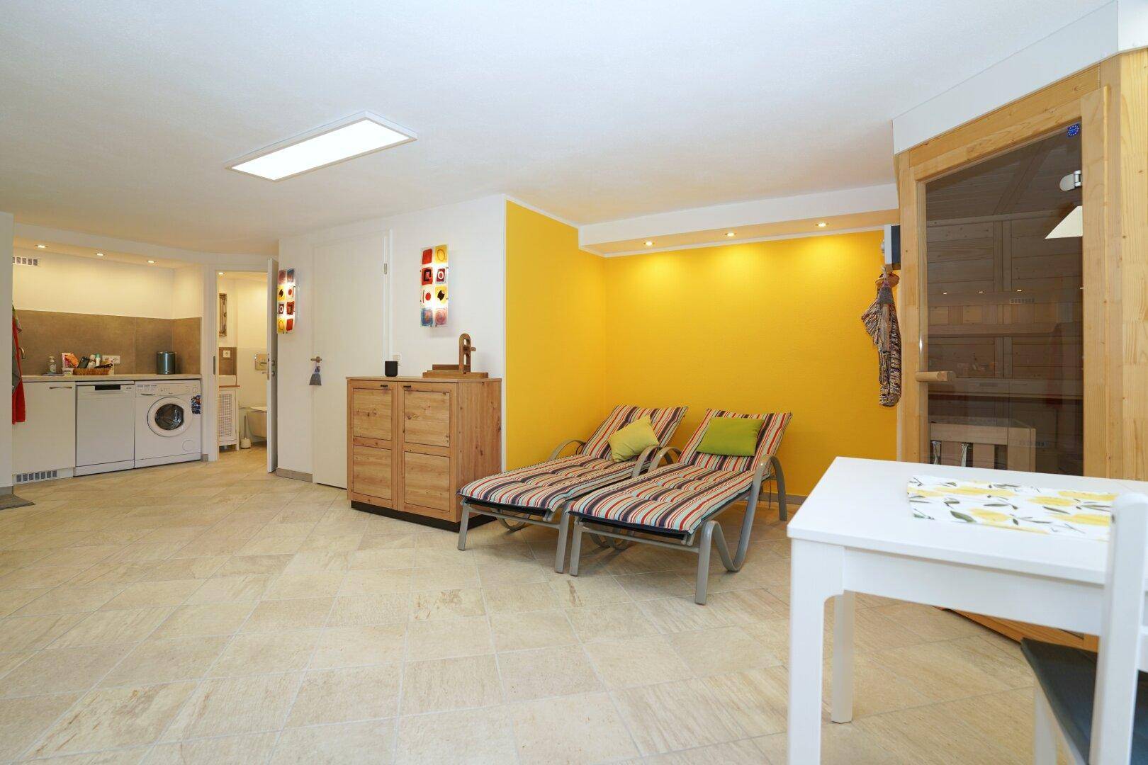 Entspannungsbereich im Untergeschoss mit Liegen und Zugang zur Sauna.
