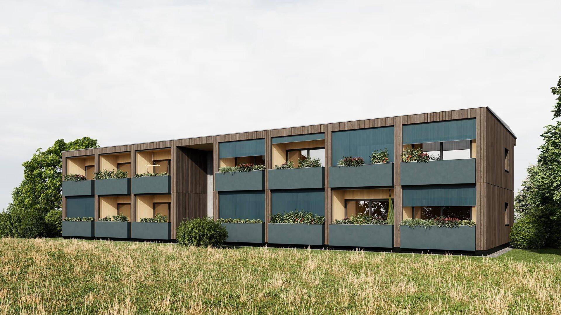 Modernes Mehrfamilienhaus mit Holzfassade und Balkonen in ländlicher Umgebung.
