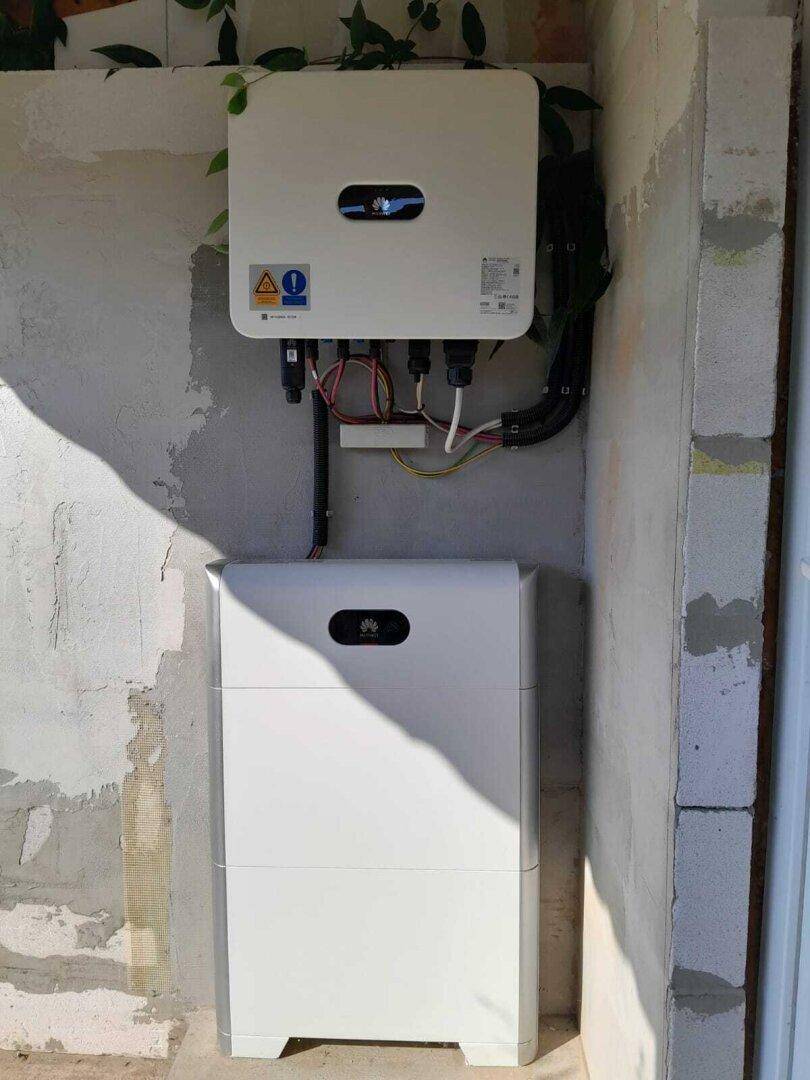 Außenwand mit modernen Huawei Wechselrichtern und Batteriespeicher für die Solaranlage.