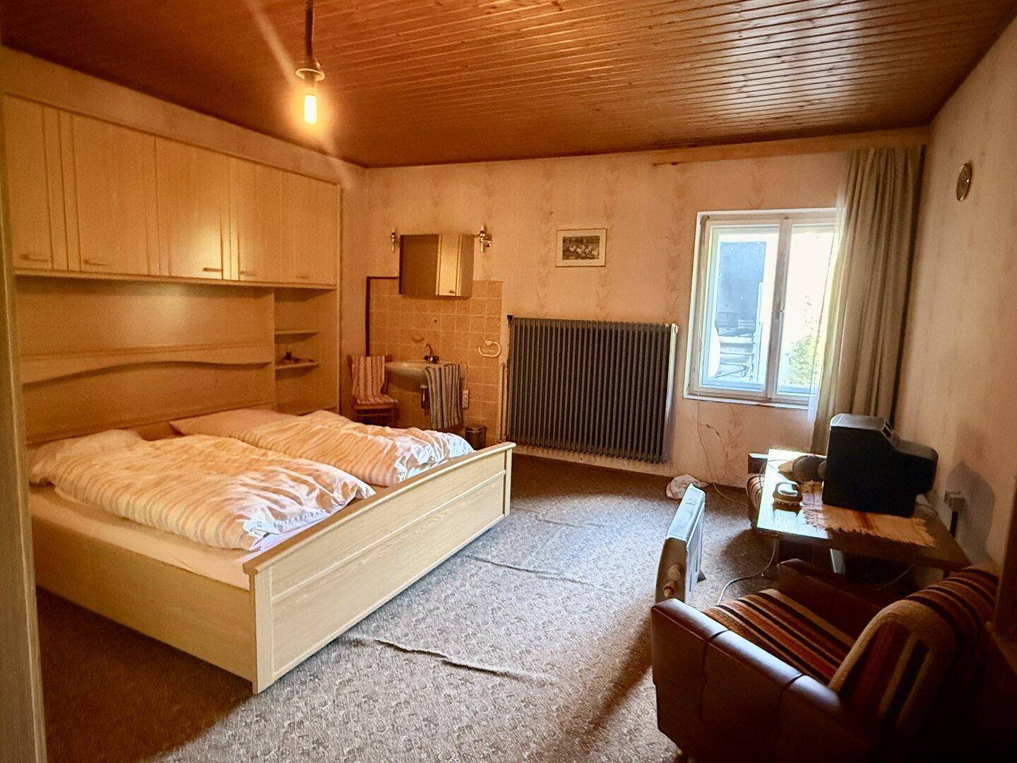 Gemütliches Schlafzimmer mit zwei Einzelbetten, Holzmöbeln und einem Heizkörper im traditionellen Stil.