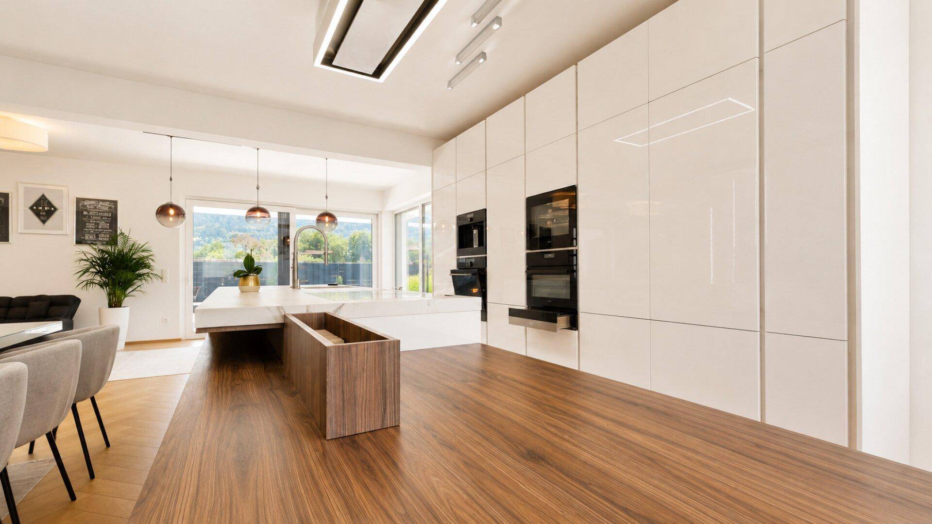 Elegante, moderne Küche mit weißen Hochglanzfronten, integrierten Geräten und Holztheke.