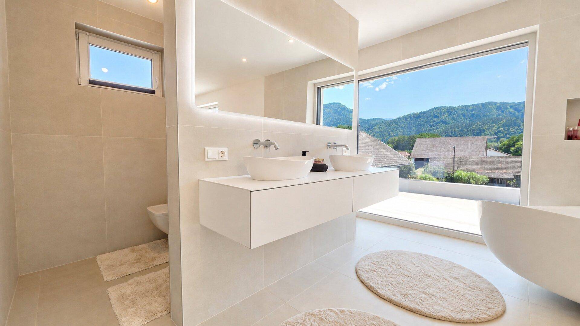 Modernes Badezimmer mit Doppelwaschbecken, großer Fensterfront und Bergblick.