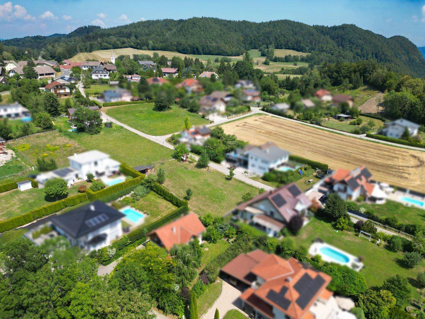 Überblick aus der Luft über eine Wohnsiedlung mit Einfamilienhäusern und viel Grünfläche.