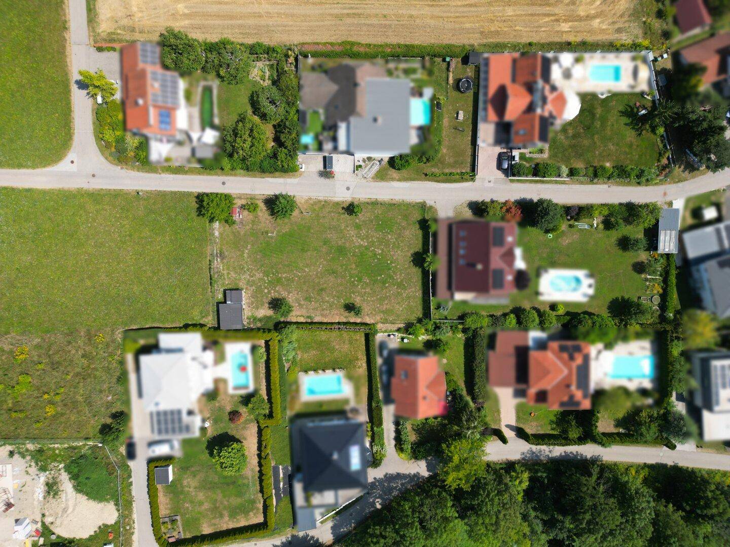 Senkrechte Luftaufnahme von Wohnparzellen mit Häusern, Gärten und einigen Pools.