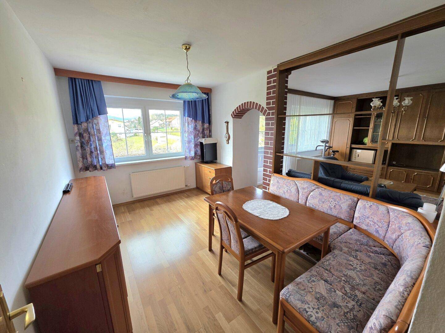 Essbereich mit Eckbank, Holztisch und offener Verbindung zum angrenzenden Wohnzimmer.
