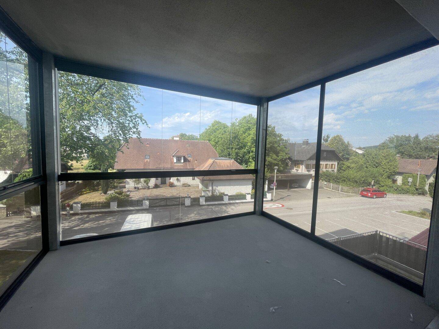 Verglaste Loggia mit weitem Blick über die Nachbarschaft und viel natürlichem Licht.