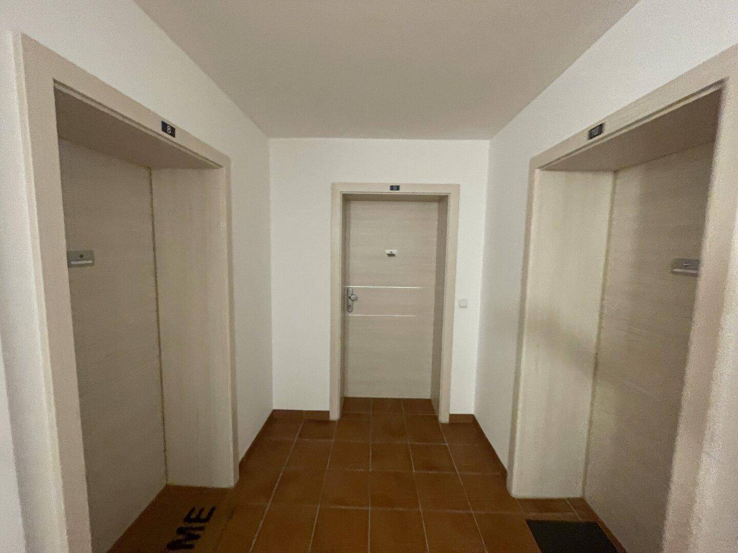 Gemeinschaftlicher Flur mit zwei Aufzügen und Zugang zu den Wohneinheiten.