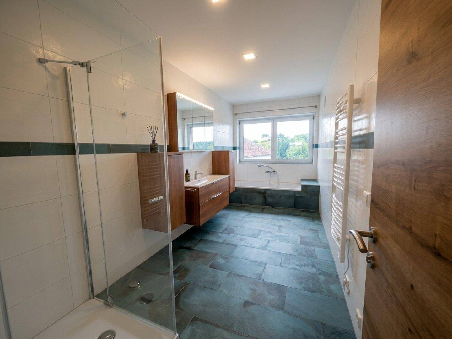 Modernes Badezimmer mit begehbarer Dusche, Badewanne, Einzelwaschbecken und Fenster.