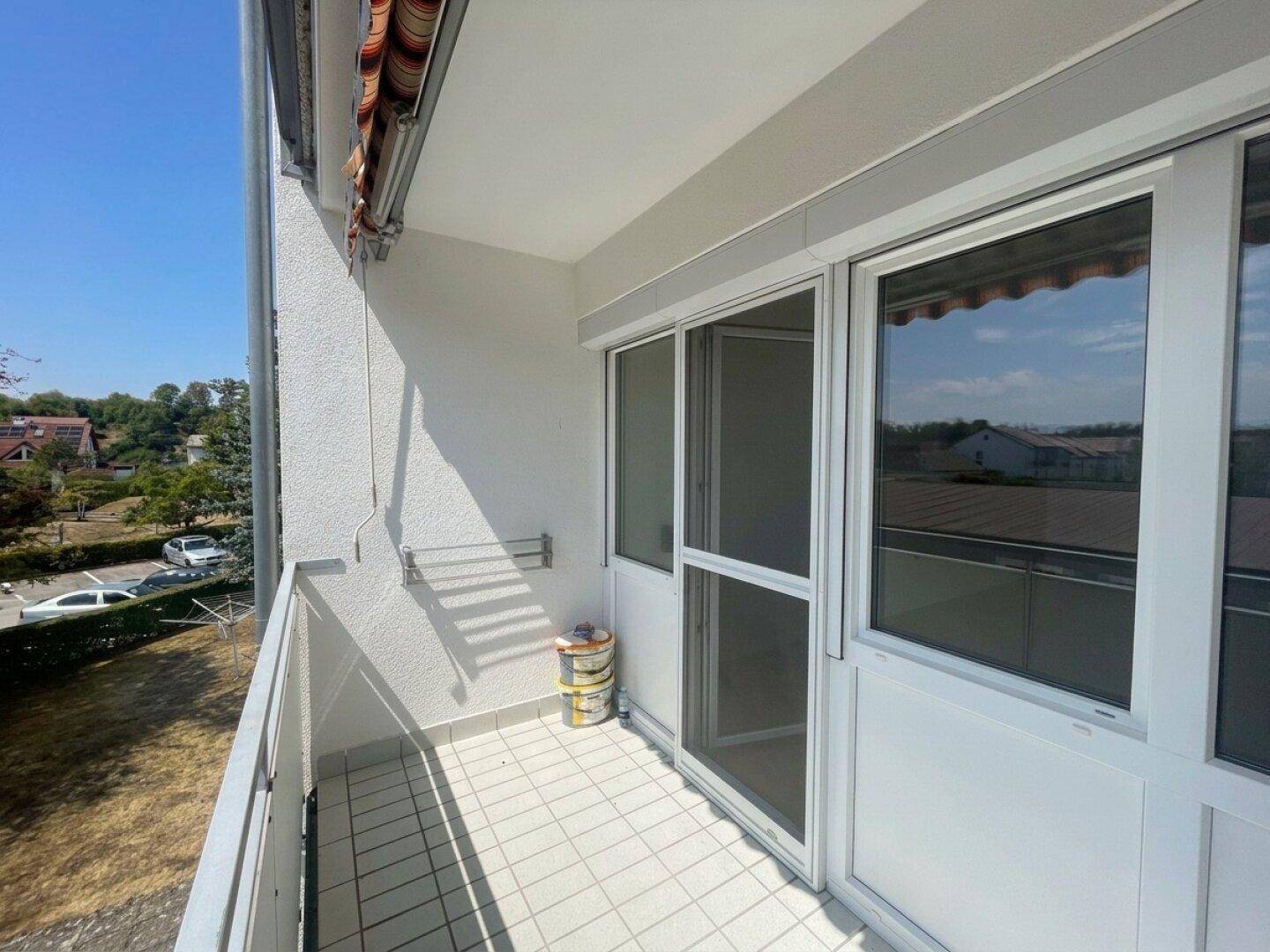 Balkon mit Fliesenboden und Blick auf die Umgebung.
