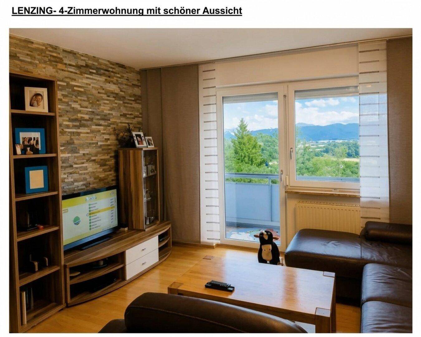 Helles Wohnzimmer mit Sofa, TV-Möbel und Zugang zum Balkon, mit schöner Berg- und Fernsicht.
