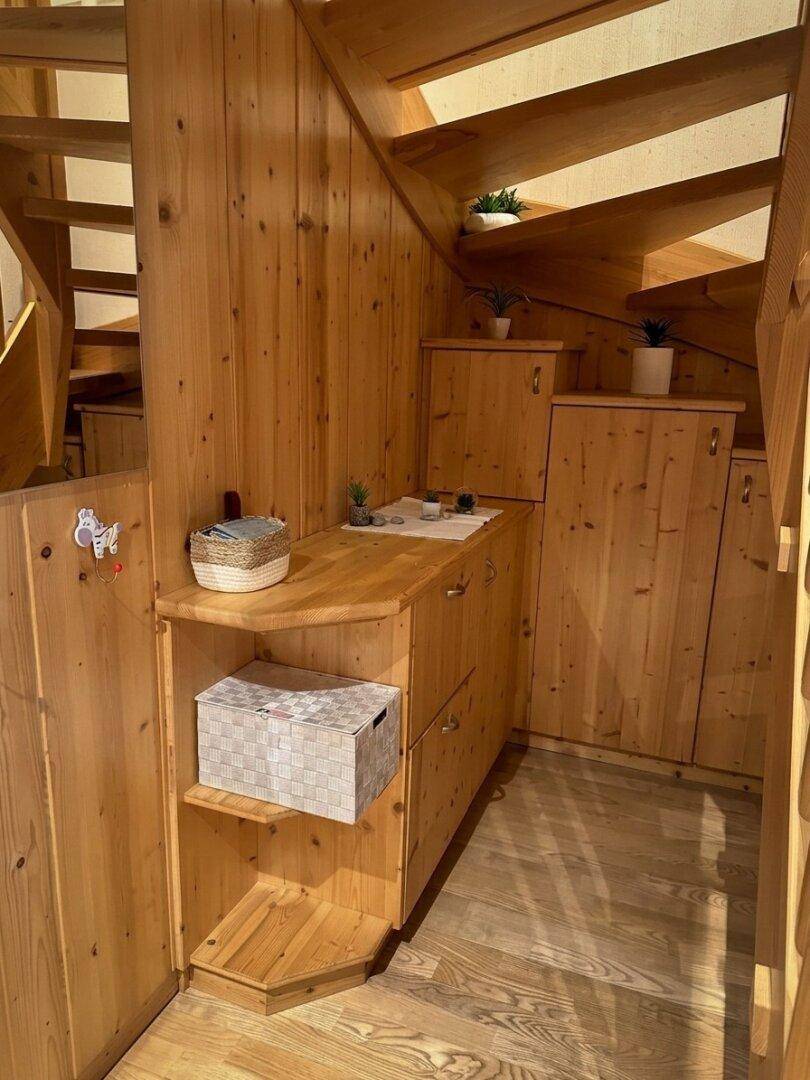 Rustikaler Treppenbereich mit Holzverkleidung und integrierten Stauschränken.