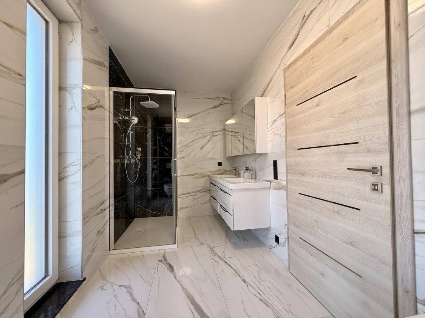 Elegantes Badezimmer mit begehbarer Dusche, Doppelwaschbecken und Marmorfliesen für gehobenen Komfort.