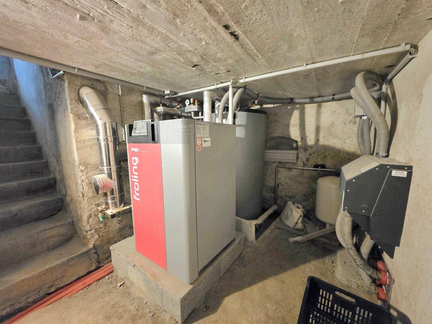 Heizungsraum im Keller mit moderner Froling-Heizanlage und Warmwasserspeichern.