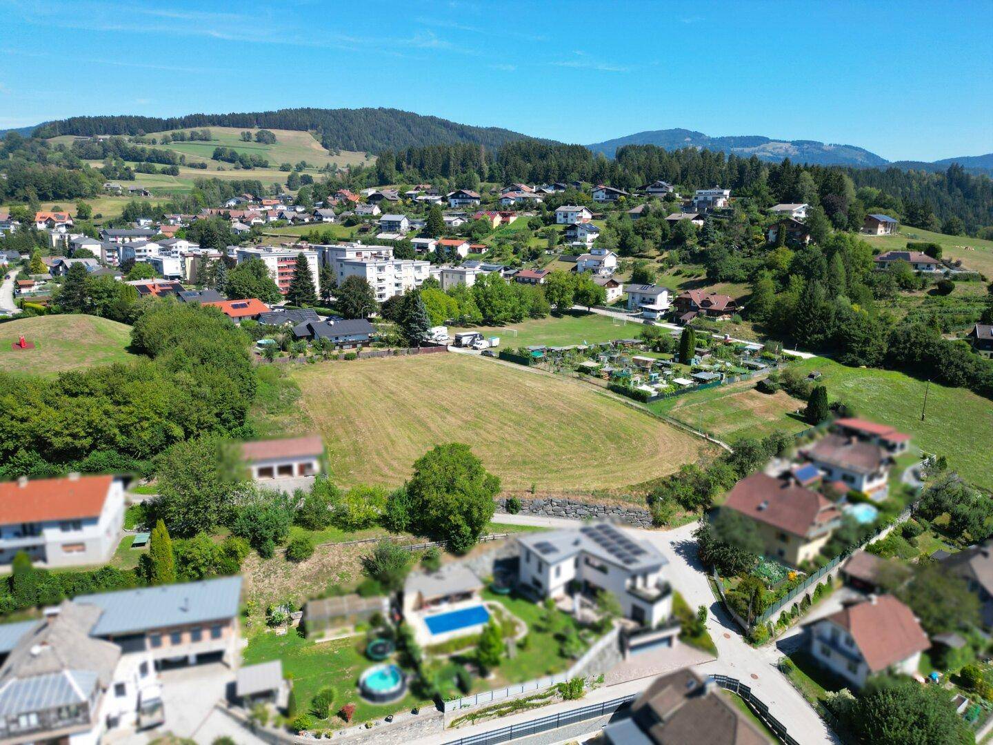 Luftaufnahme eines Grundstücks in einer Wohnsiedlung mit angrenzenden Häusern und Pools.