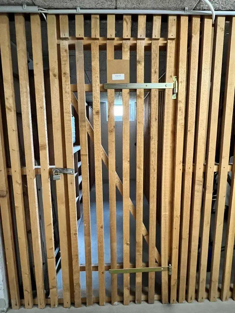 Kellerabteil mit Holzlattenwand und sicherem Verschluss, ideal für Lagerung.