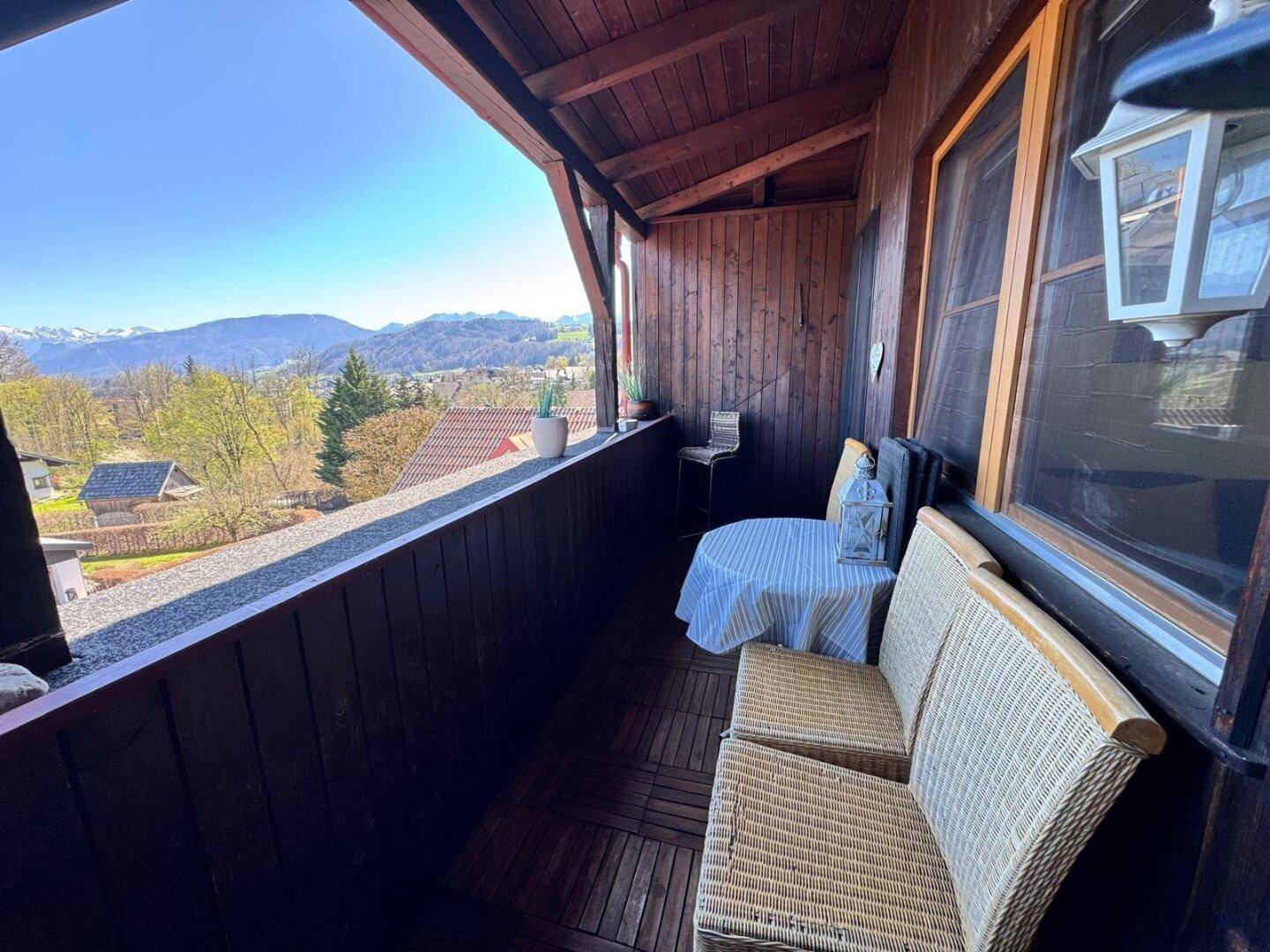 Gemütlicher Holzbalkon mit Sitzgelegenheiten und weitem Blick auf die Berge.